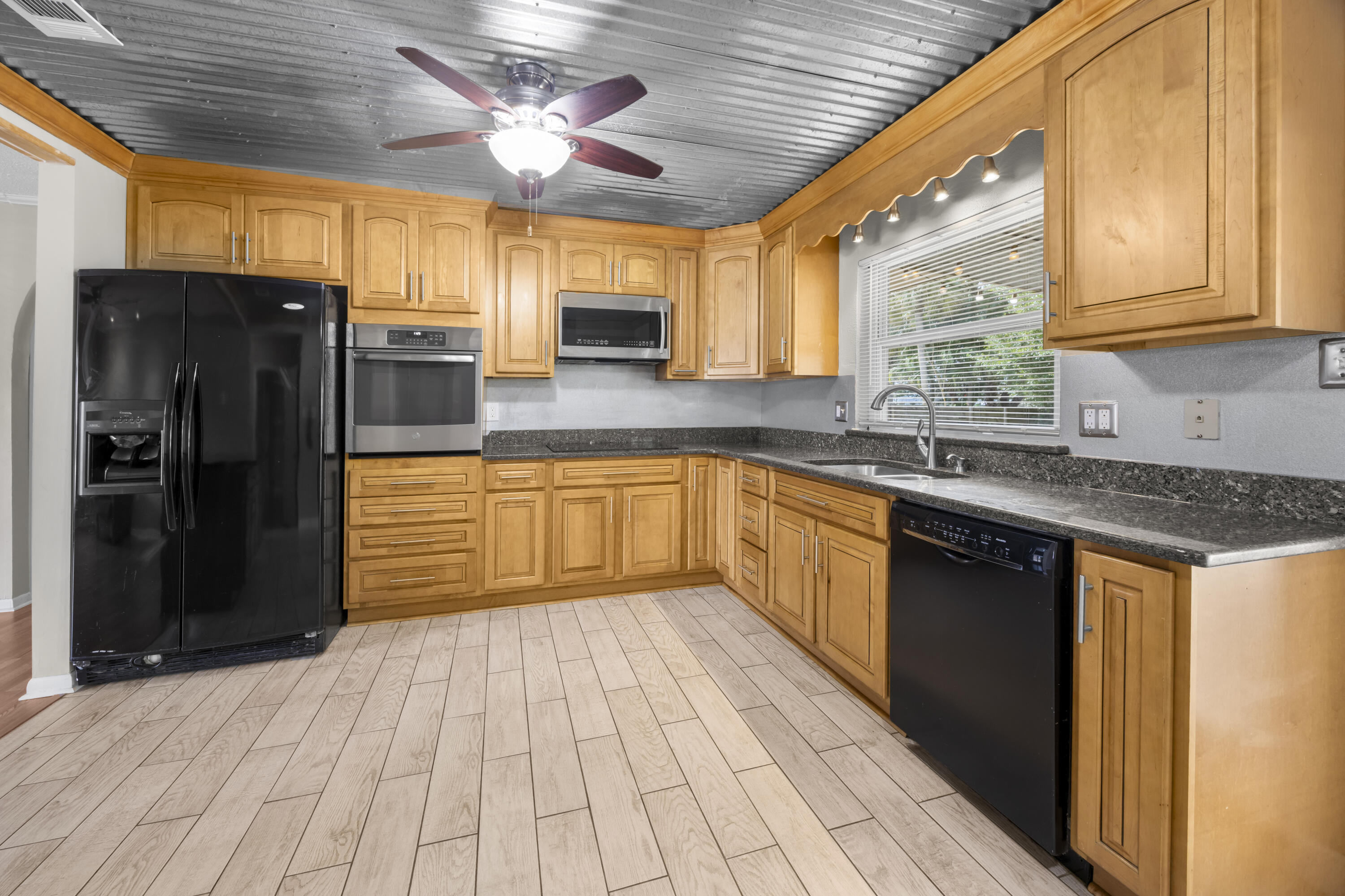 307 Spring Lane Destin, FL 32541 - Photo 14 of 42 a kitchen with stainless steel appliances granite countertop a sink cabinets and a refrigerator