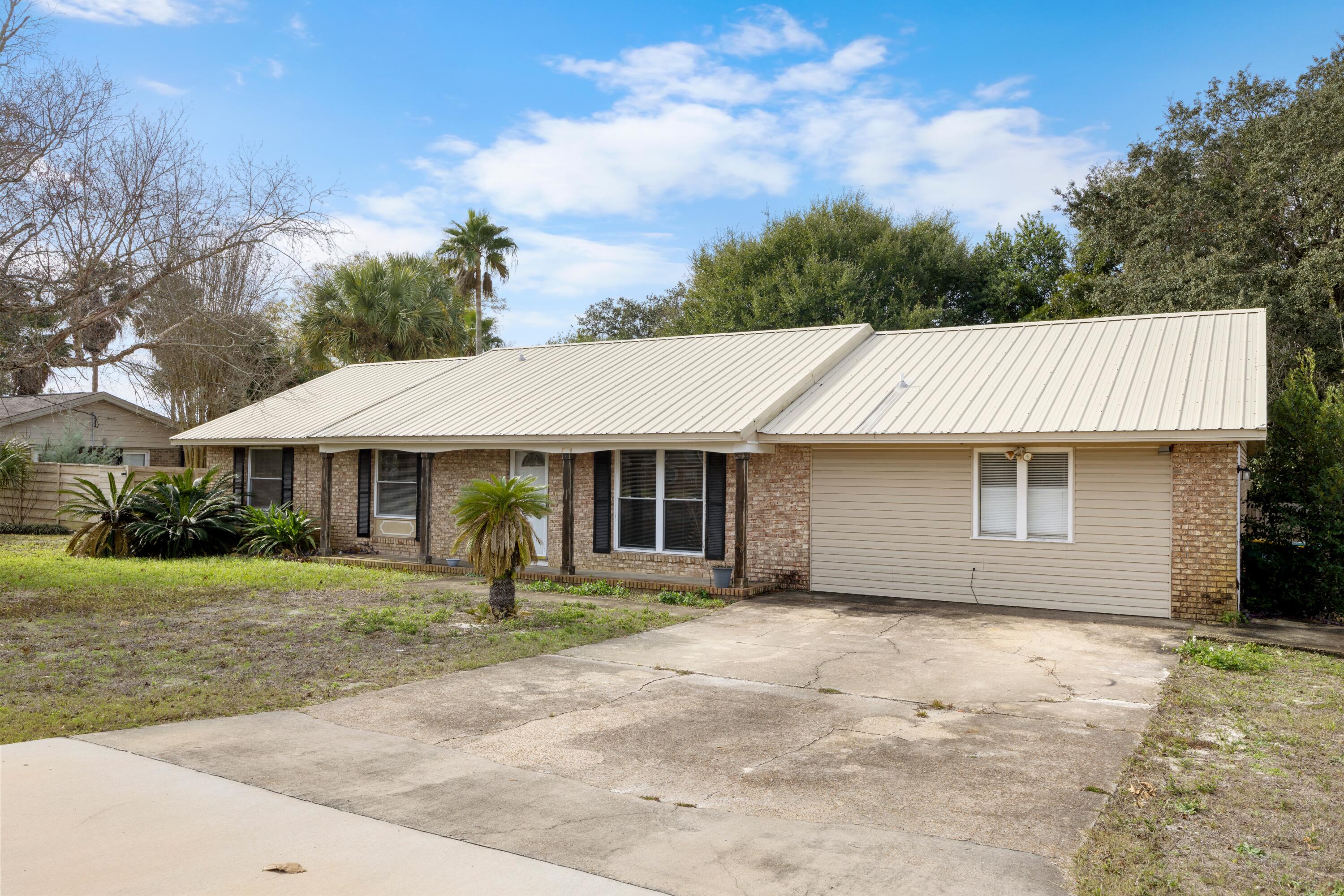 307 Spring Lane Destin, FL 32541 - Photo 2 of 42 a backyard of a house with yard and garage