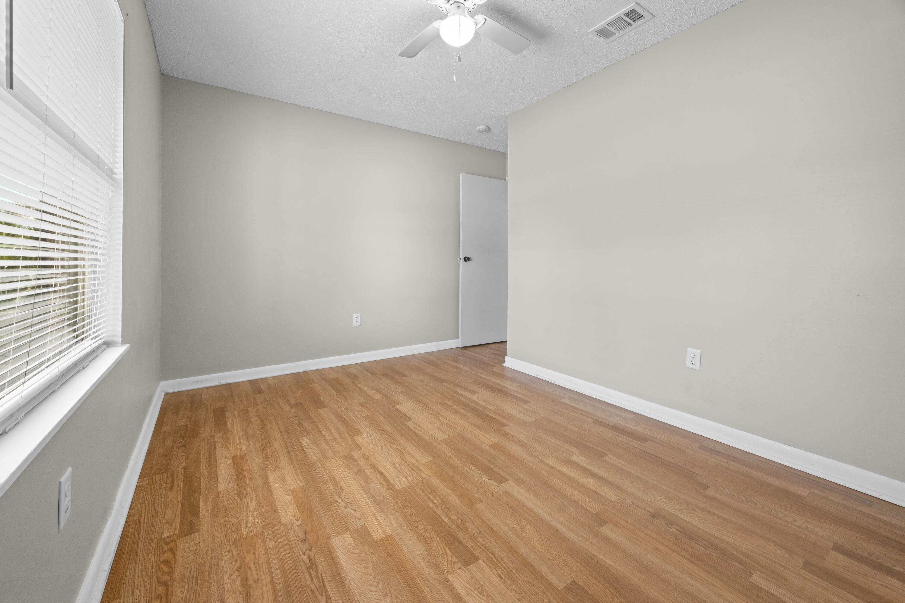 307 Spring Lane Destin, FL 32541 - Photo 29 of 42 wooden floor in an empty room with a window