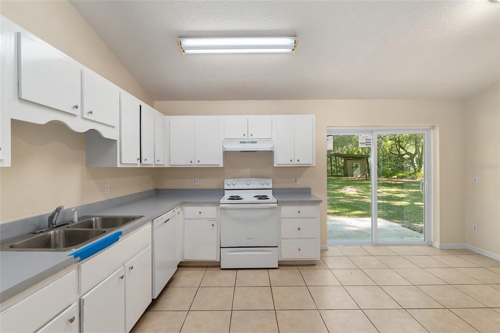4329 Northwest 155th Street Reddick, FL 32686 - Photo 25 of 52 a kitchen with a stove top oven sink and cabinets