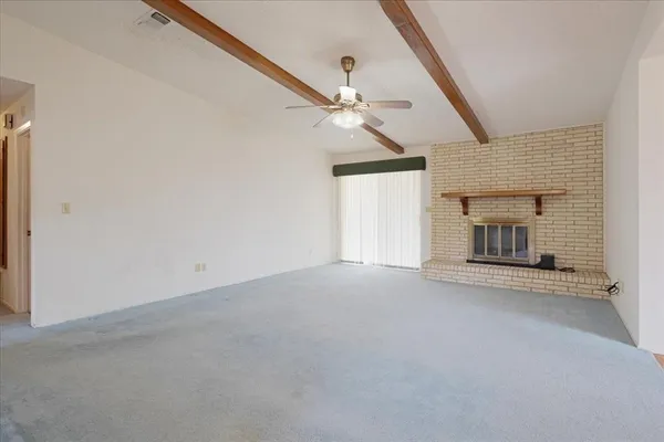 an empty room with a ceiling fan and a window