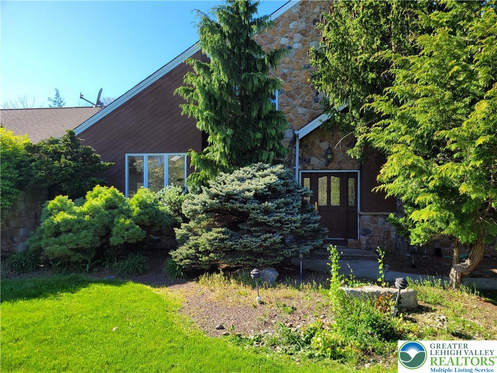 a front view of a house with a yard and a garden