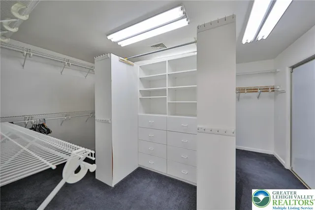 a view of a hallway with wooden floor and a flat screen tv
