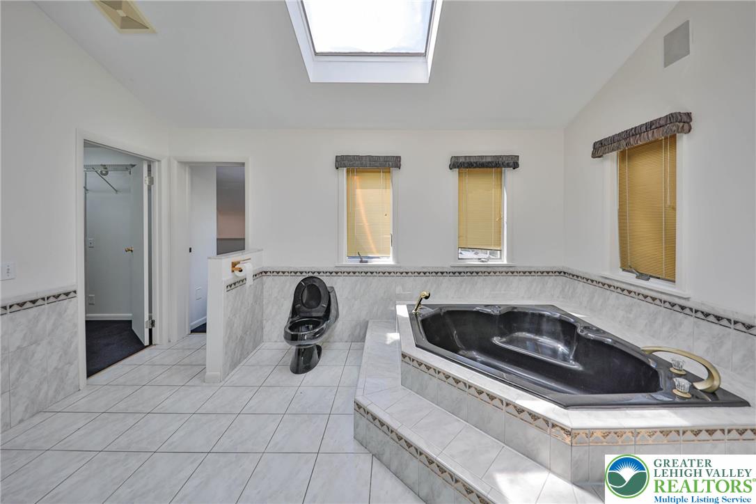 1015 Honeysuckle Road Walnutport, PA 18088 - Photo 26 of 75 a bathroom with a sink a mirror and a bathtub