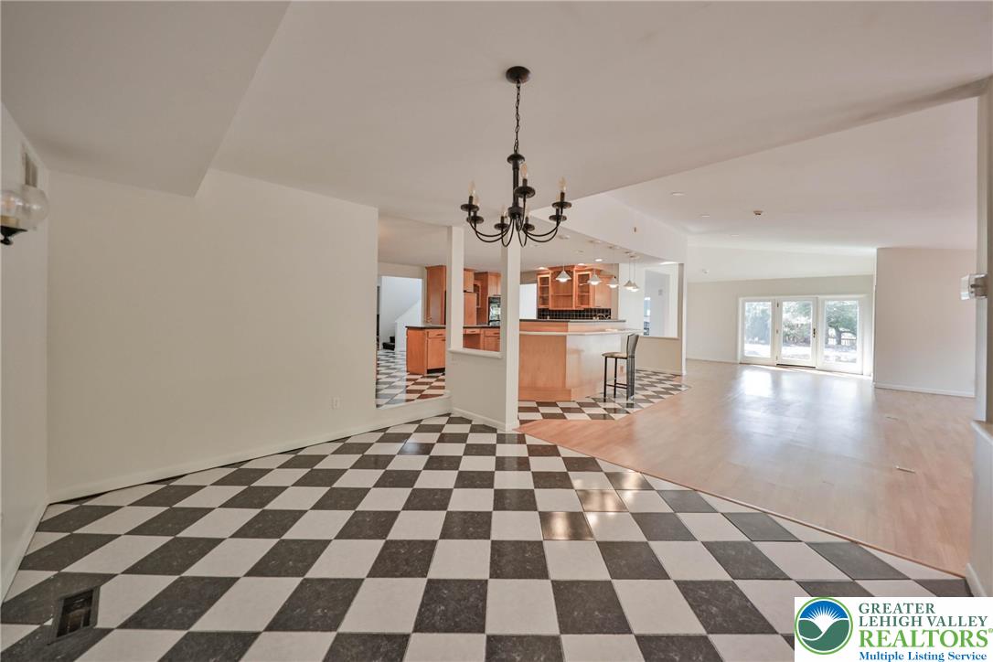 1015 Honeysuckle Road Walnutport, PA 18088 - Photo 35 of 75 a living room with a black white checkered floor with a gaming machine and dining table