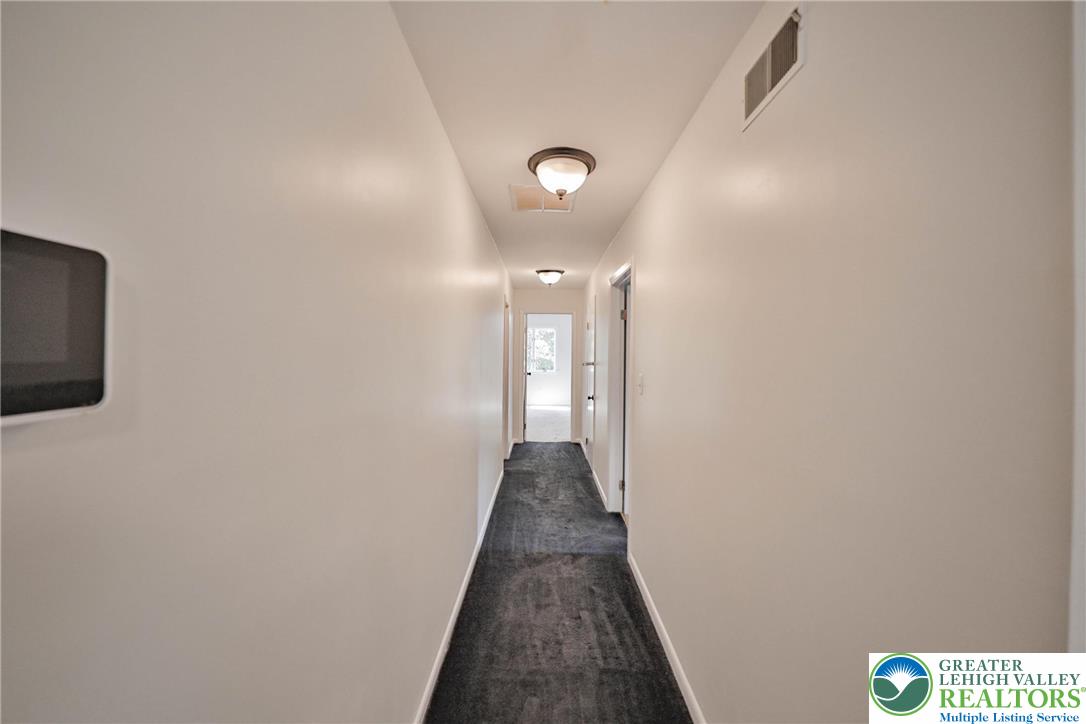 1015 Honeysuckle Road Walnutport, PA 18088 - Photo 39 of 75 a view of a hallway with wooden floor and a flat screen tv
