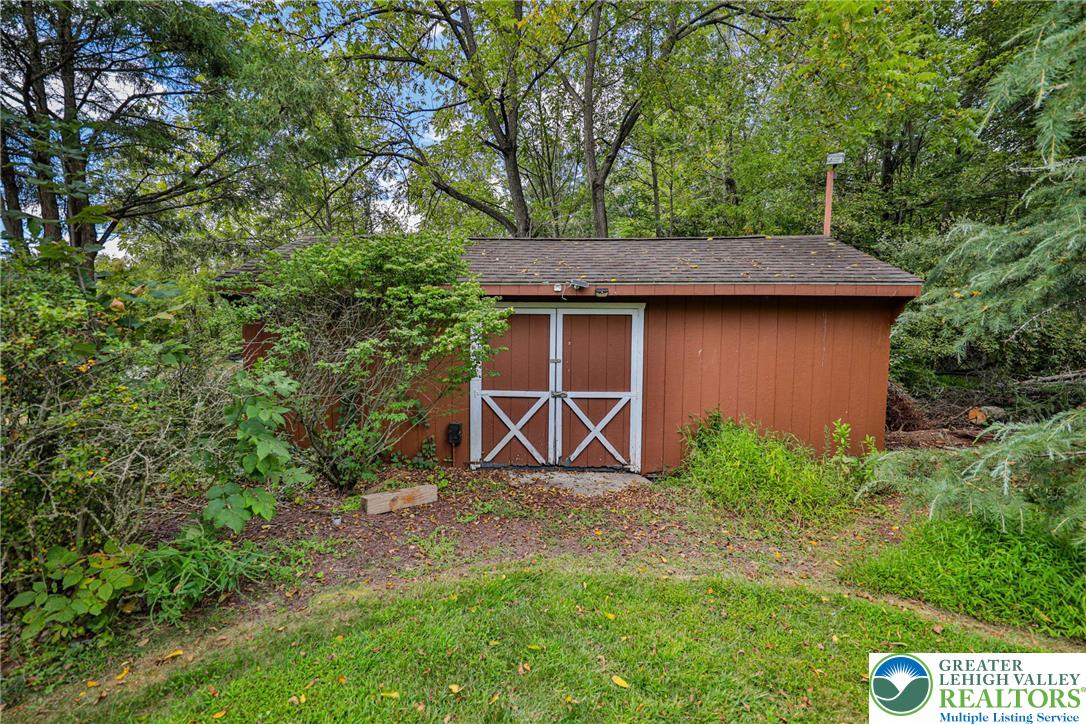 1015 Honeysuckle Road Walnutport, PA 18088 - Photo 65 of 75 a view of a backyard with plants and a large tree