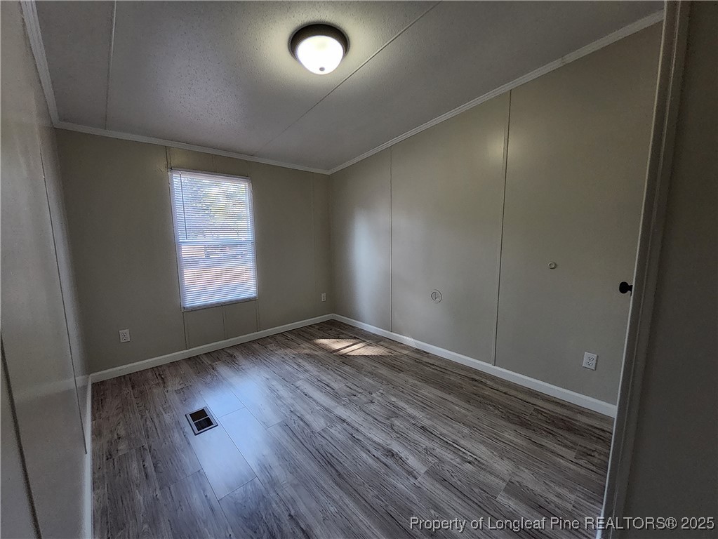 87 Drox Lane Clinton, NC 28328 - Photo 14 of 22 an empty room with wooden floor and windows
