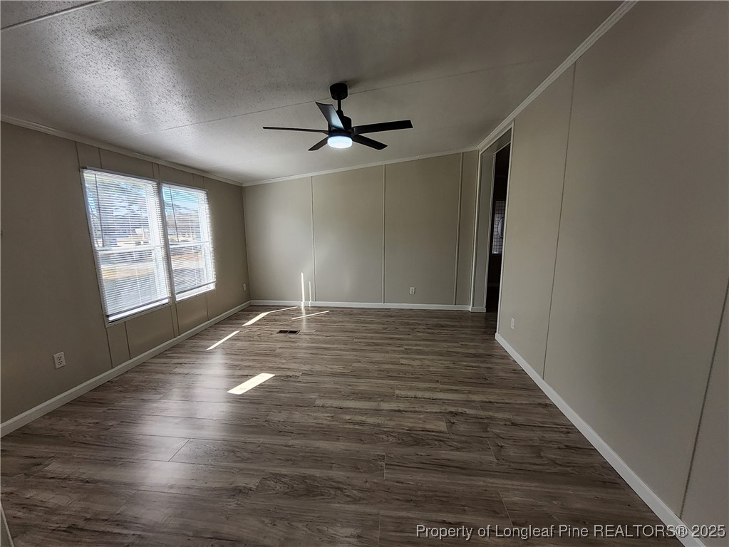 87 Drox Lane Clinton, NC 28328 - Photo 17 of 22 an empty room with wooden floor ceiling fan and windows