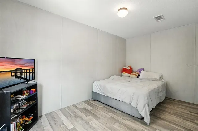 a living room with furniture kitchen view and a wooden floor