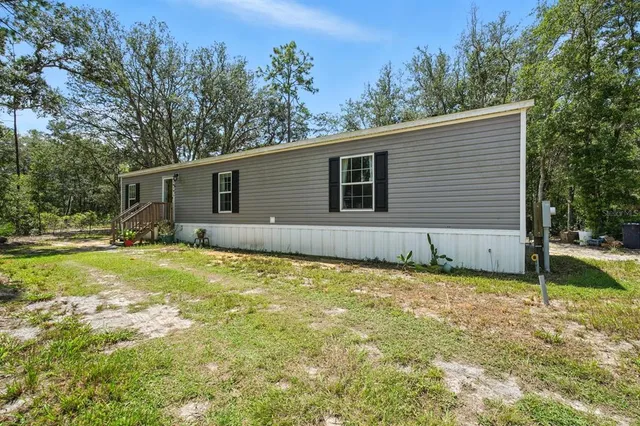 a view of a house with a yard and sitting area