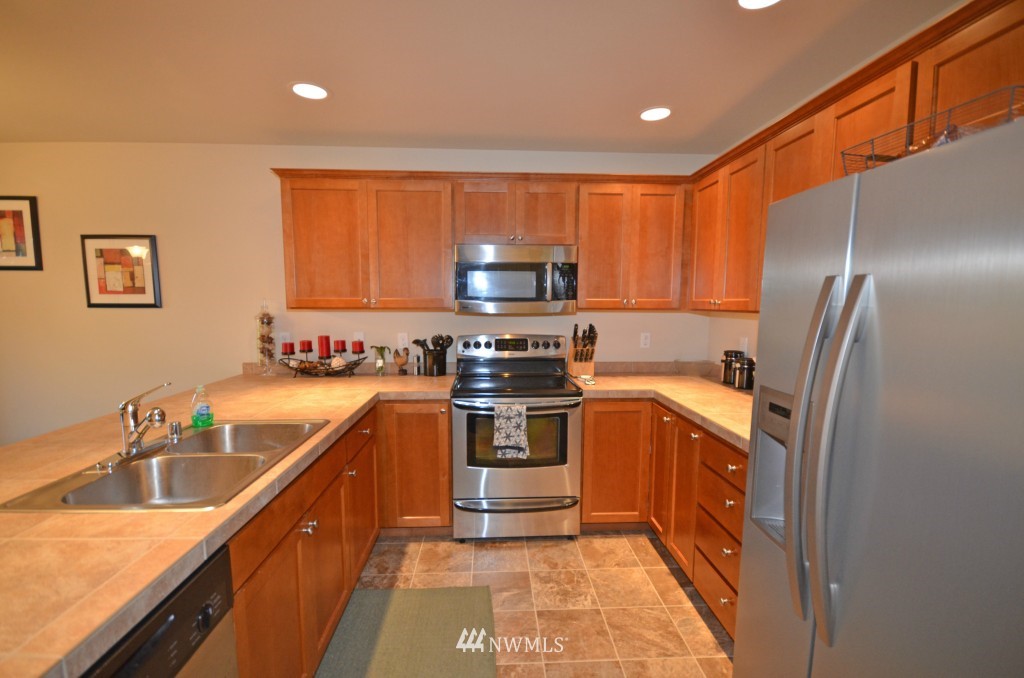 11 194th Street Southwest Bothell, WA 98012 - Photo 2 of 10 a kitchen with stainless steel appliances granite countertop a sink stove and refrigerator