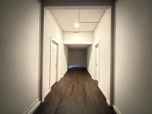 a view of a hallway with wooden floor