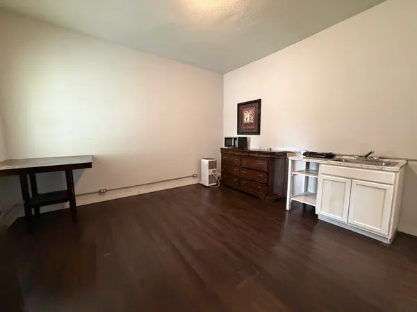 a view of a workspace with wooden floor and white cabinet