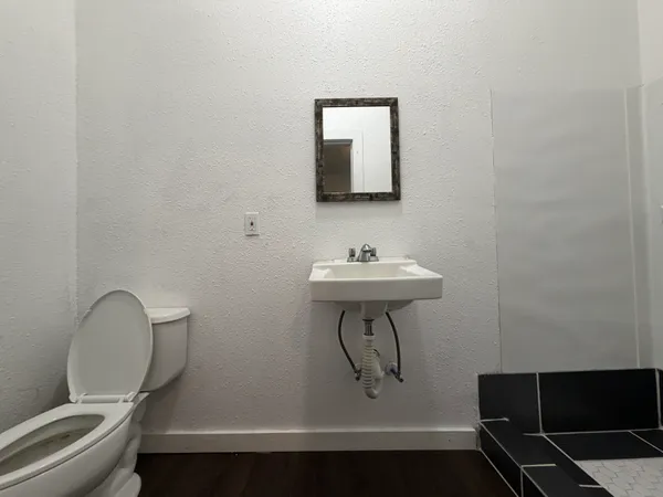 a bathroom with a sink toilet and a mirror