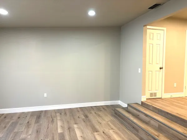 a view of an empty room with wooden floor