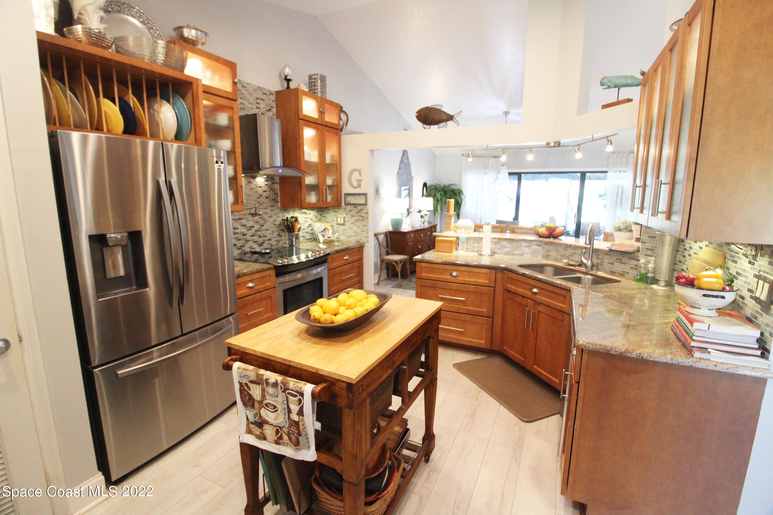 2397 Chase Hammock Road Merritt Island, FL 32953 - Photo 18 of 35 a kitchen with stainless steel appliances granite countertop a refrigerator a sink a stove and white cabinets