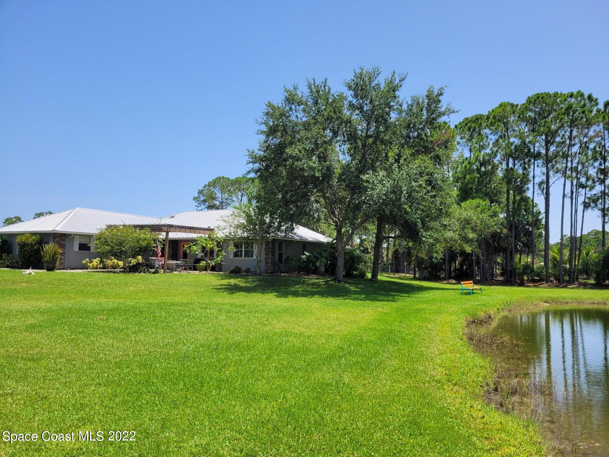 2397 Chase Hammock Road Merritt Island, FL 32953 - Photo 2 of 35 a view of a big yard with plants and large trees