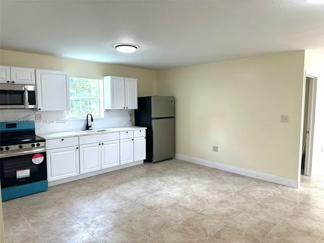 a kitchen with stainless steel appliances a refrigerator sink and microwave