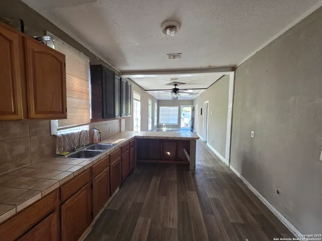a large kitchen with a large window a sink and stainless steel appliances