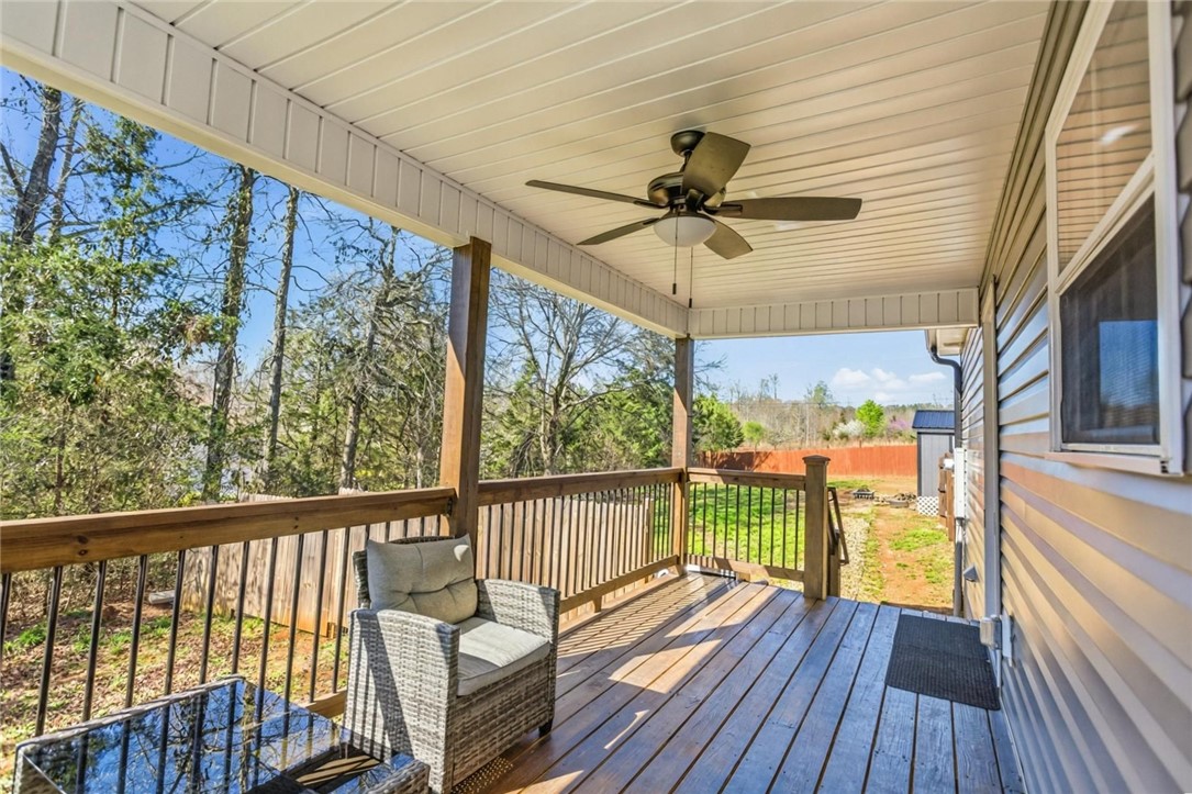 745 Dave Nix Road Seneca, SC 29678 - Photo 4 of 23 A well-lit covered deck offers a serene outdoor retreat overlooking natural surroundings.