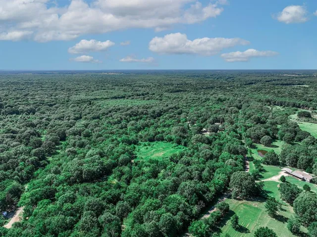 a view of a big yard of grass and basketball court