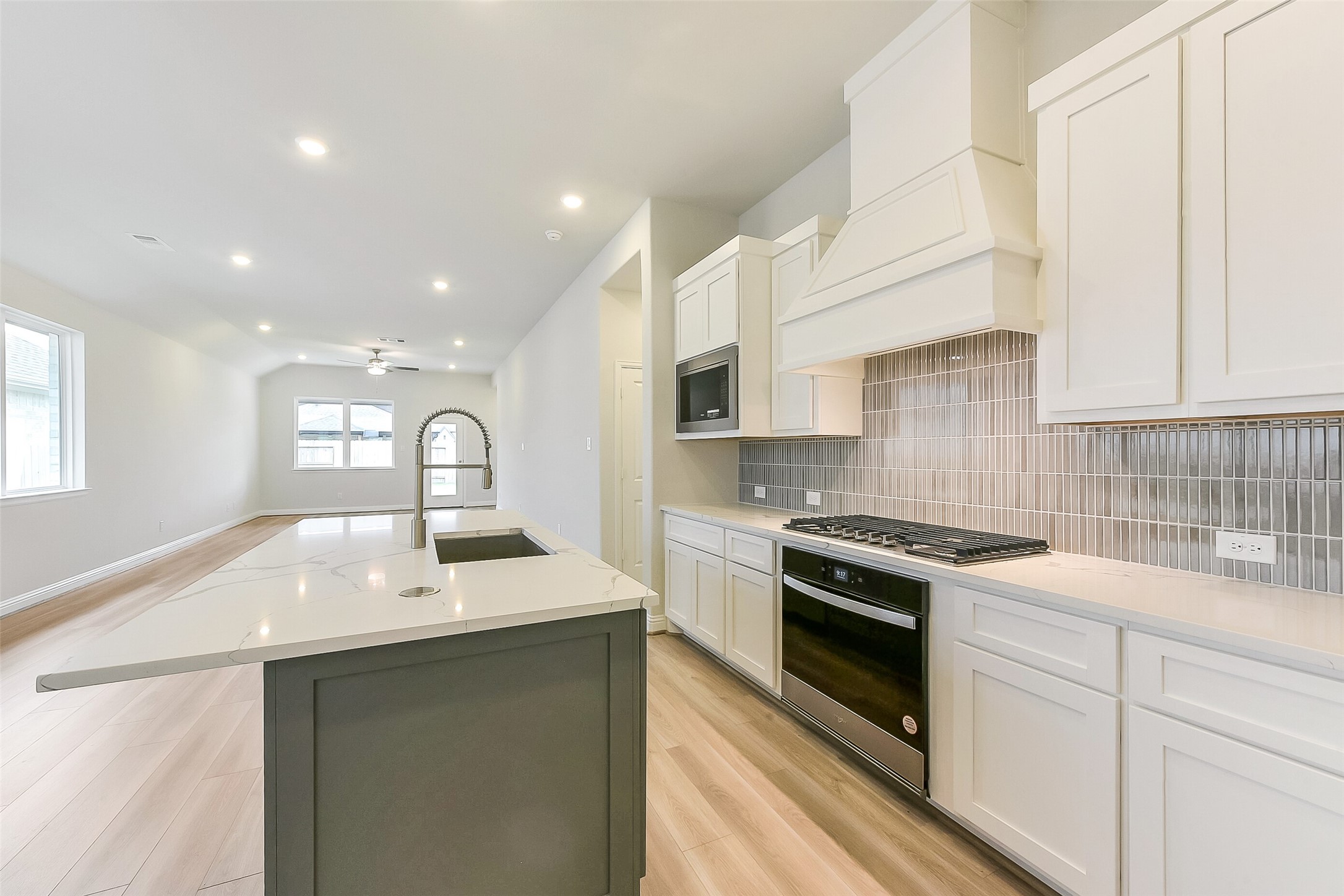 16323 Placid Stream Street Conroe, TX 77302 - Photo 14 of 36 a kitchen with granite countertop a sink stainless steel appliances and white cabinets