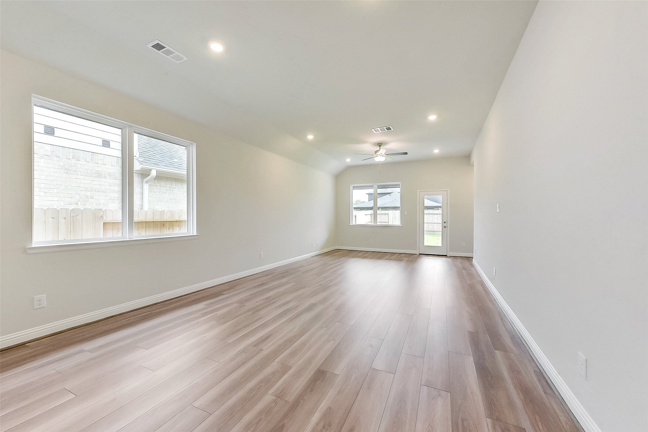 16323 Placid Stream Street Conroe, TX 77302 - Photo 6 of 36 an empty room with wooden floor and windows