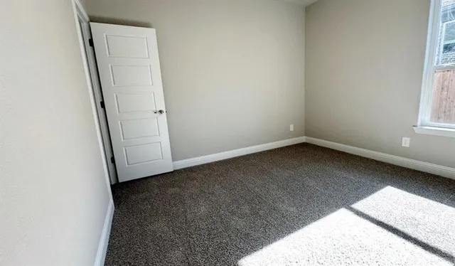 an empty room with closet and mirrors