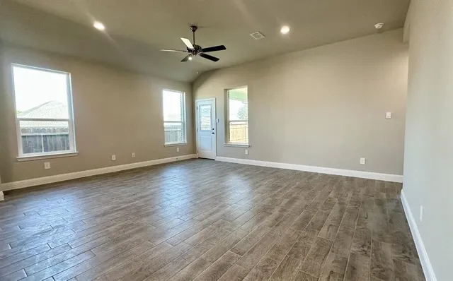 an empty room with wooden floor and entrance