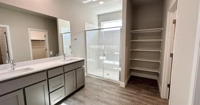an empty room with chandelier fan and windows