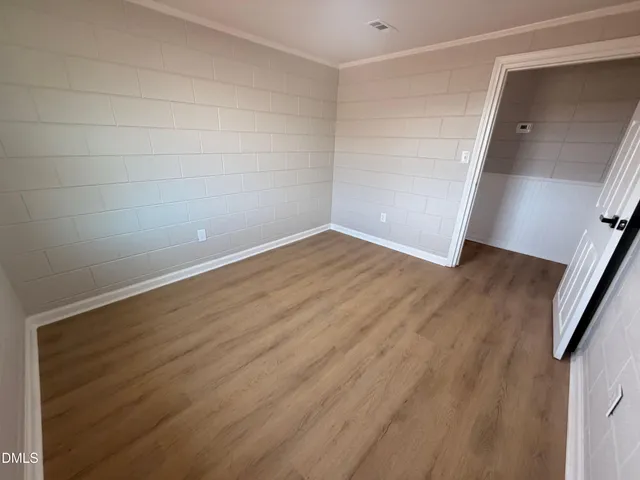 a view of an empty room with wooden floor