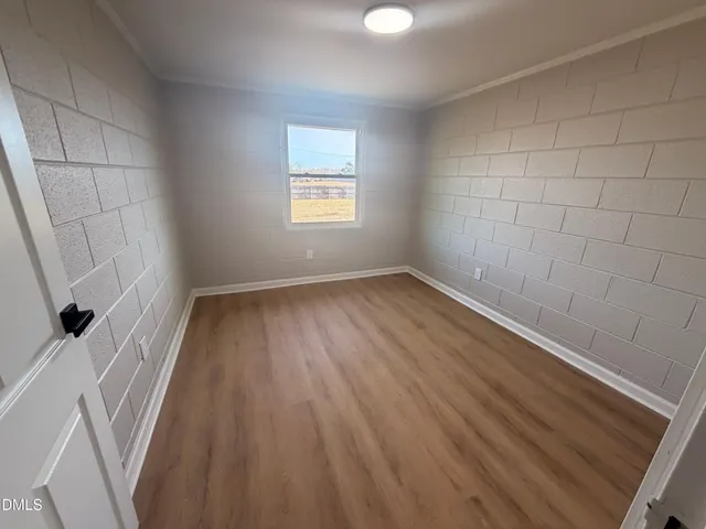 a view of a room with wooden floor and white walls