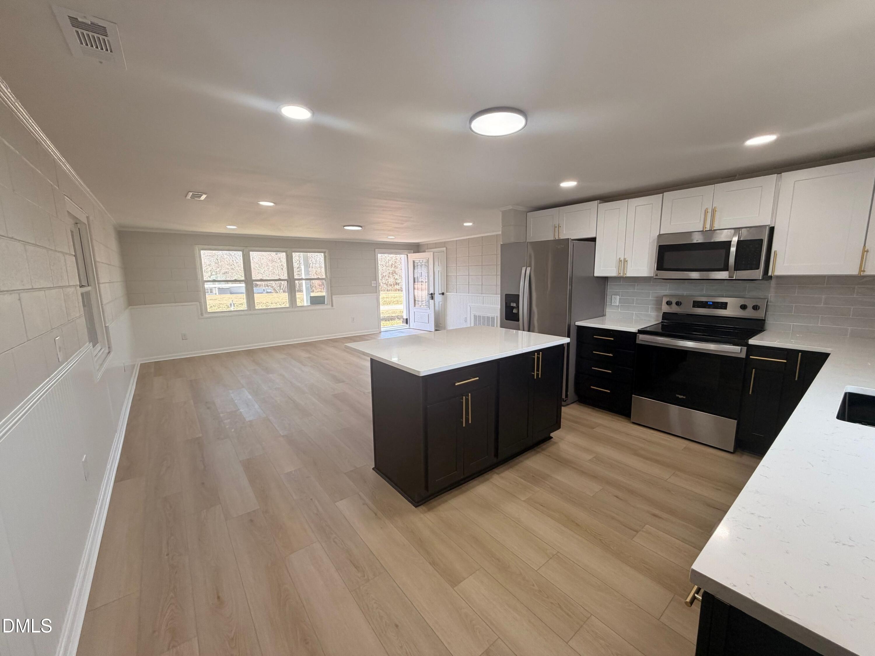 206 W Road Angier, NC 27501 - Photo 5 of 23 a large kitchen with stainless steel appliances granite countertop a large counter top a sink a refrigerator and a stove