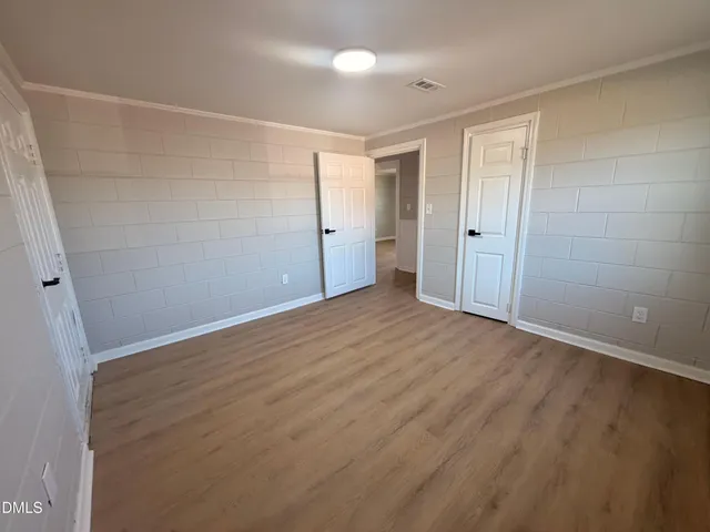 a view of an empty room with wooden floor