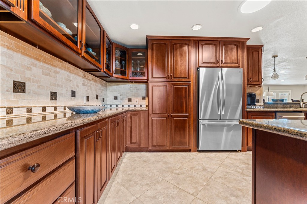 5737 Peridot Avenue Rancho Cucamonga, CA 91701 - Photo 14 of 40 a kitchen with stainless steel appliances granite countertop a refrigerator a stove and a sink with wooden cabinets