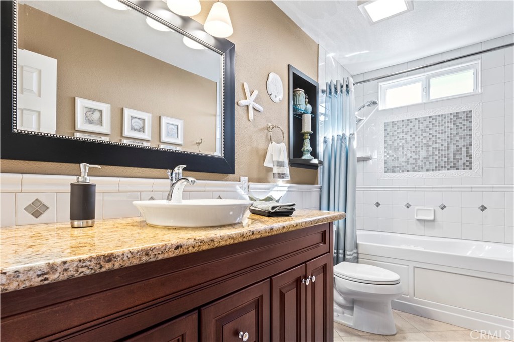 5737 Peridot Avenue Rancho Cucamonga, CA 91701 - Photo 25 of 40 a bathroom with a granite countertop toilet sink and mirror