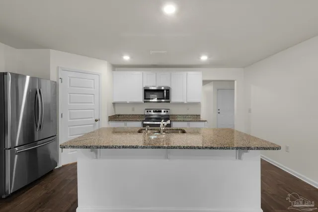 a kitchen with a refrigerator a microwave a sink and a stove