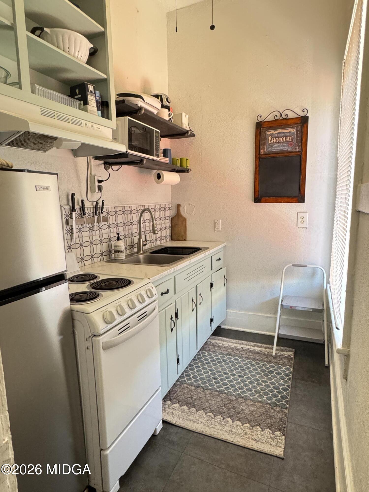 1687 Lawton Avenue Macon, GA 31201 - Photo 21 of 22 a kitchen with stainless steel appliances granite countertop a sink stove and refrigerator