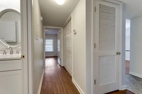 a view of a hallway with wooden floor and staircase