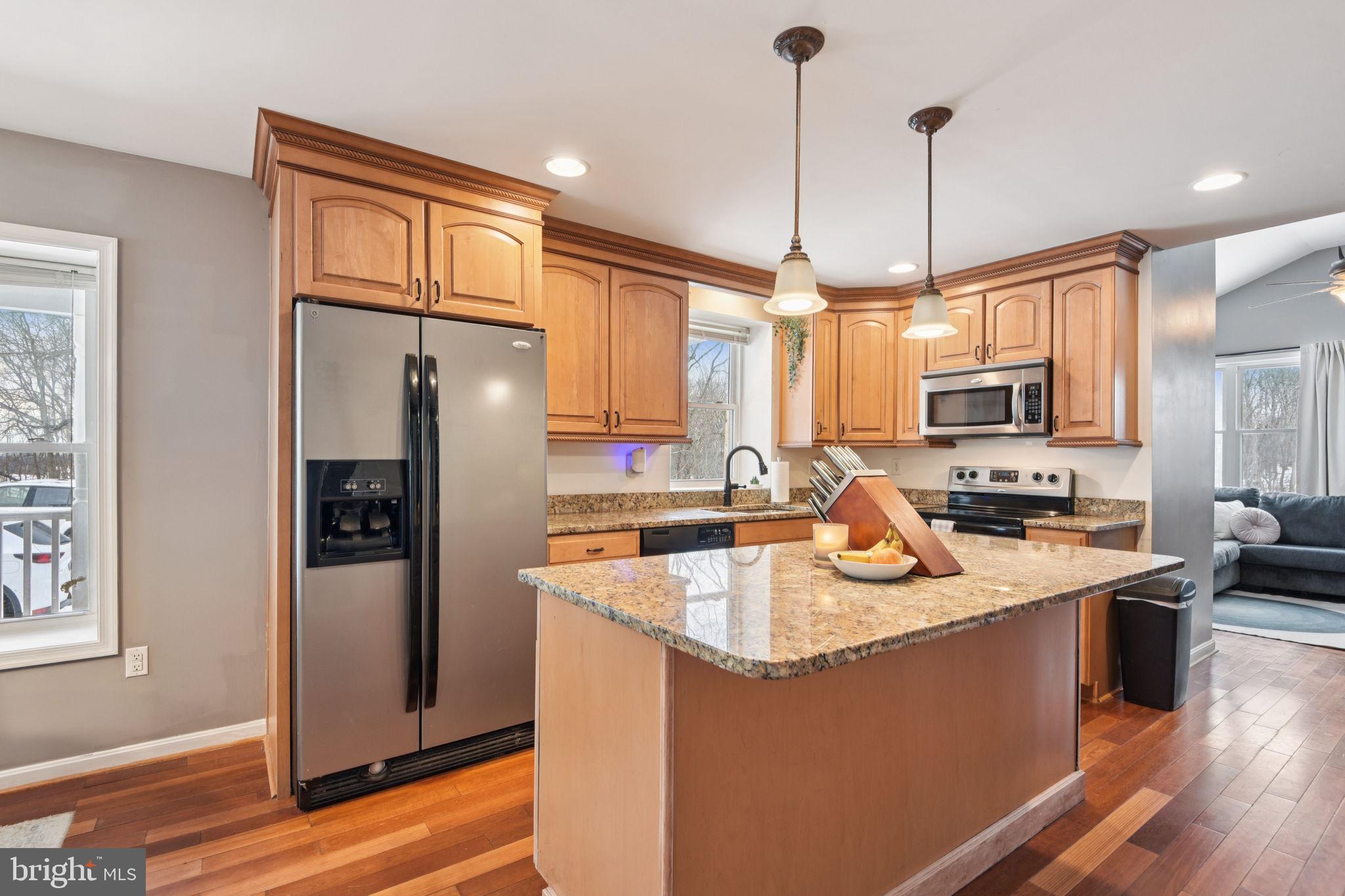 14844 Toll Road New Windsor, MD 21776 - Photo 12 of 30 a kitchen with stainless steel appliances granite countertop a refrigerator a sink a stove and a wooden floors