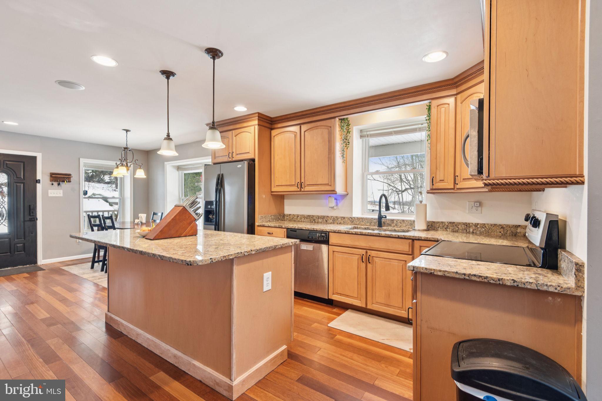 14844 Toll Road New Windsor, MD 21776 - Photo 13 of 30 a kitchen with kitchen island granite countertop a sink a counter top space appliances and cabinets