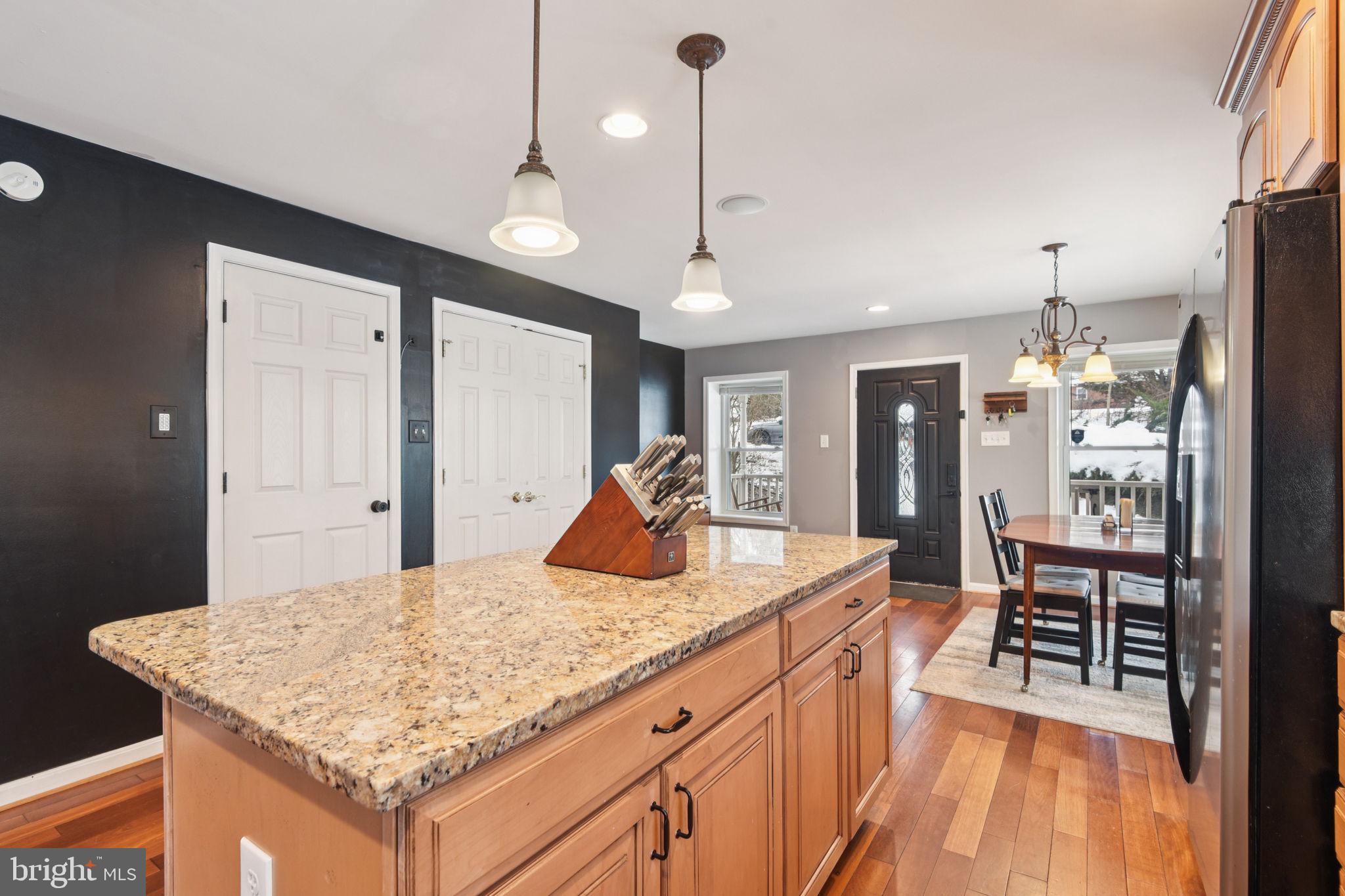14844 Toll Road New Windsor, MD 21776 - Photo 14 of 30 a kitchen with kitchen island granite countertop wooden floor and a refrigerator