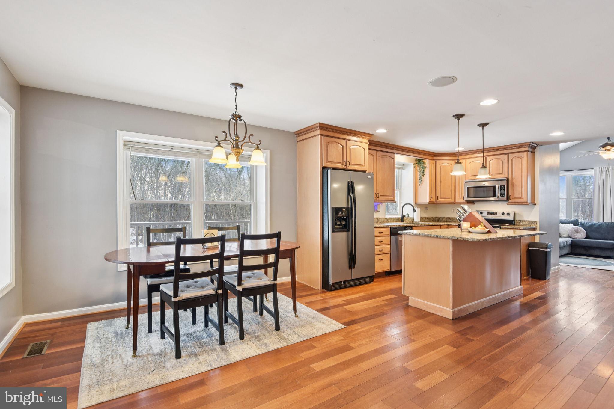 14844 Toll Road New Windsor, MD 21776 - Photo 8 of 30 a kitchen with stainless steel appliances kitchen island granite countertop a table chairs and a refrigerator