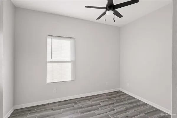 an empty room with a window and a ceiling fan