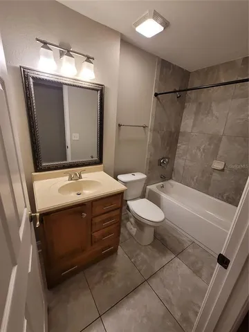 a bathroom with a sink and mirror with bathtub