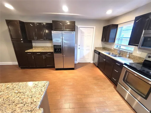 a kitchen with stainless steel appliances granite countertop a refrigerator and a stove