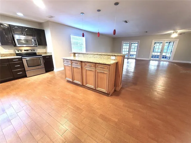 a large kitchen with stainless steel appliances granite countertop a large stove top oven a sink with granite countertops and cabinets