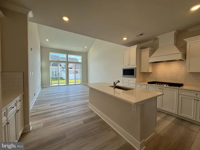 a kitchen with stainless steel appliances a stove a sink a microwave a refrigerator and cabinets