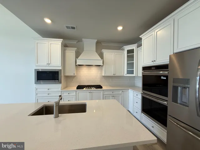 a kitchen with stainless steel appliances a refrigerator sink and microwave